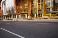 two people walking on a city street near some buildings with tall glass windows, near a street with traffic