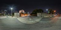 a view looking up at a city street at night from a skateboard ramp on a sidewalk