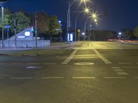 street lights at night in a city with a single lane on either side of the road