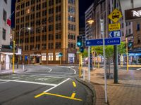 a city street with an intersection and signs in the evening time for pedestrians to cross