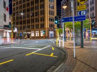 a city street with an intersection and signs in the evening time for pedestrians to cross