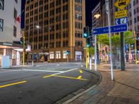 a city street with an intersection and signs in the evening time for pedestrians to cross