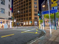 a city street with an intersection and signs in the evening time for pedestrians to cross