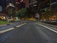 there is a deserted street in the city at night time of the day with bright lights on