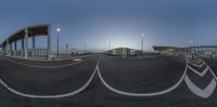 the view of some train tracks and an airport from the street at night time, with multiple traffic lights