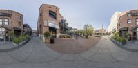 a view of a street with multiple buildings in it of the camera lens panoramicly