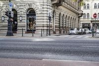 the corner of a street with people walking on it, and a car in the background