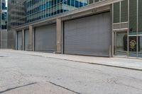 a person in a helmet on a city street near a large building with steel roller shutter doors