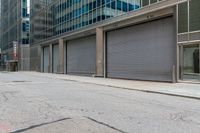 a person in a helmet on a city street near a large building with steel roller shutter doors