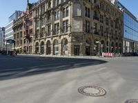 a city street scene with no people or cars on it, buildings and a manhole