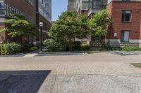 a sidewalk leading to some buildings and trees in a city street area by a park