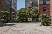 a sidewalk leading to some buildings and trees in a city street area by a park