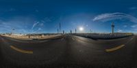 fisheye view of street with sun in background on clear sunny day from above a road