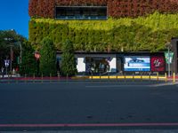 a street that has green walls and people on the side of it and two buildings