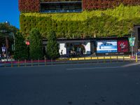 a street that has green walls and people on the side of it and two buildings