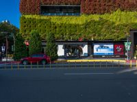 a street that has green walls and people on the side of it and two buildings