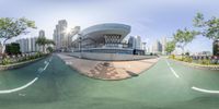 a panoramagraph shows a street near tall buildings in a city area as seen from across the street