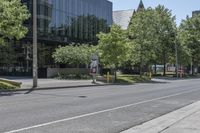 a city street with several trees lined on the side of it and a white traffic sign above