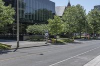 a city street with several trees lined on the side of it and a white traffic sign above