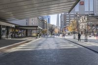 a walkway between the buildings that surround the area on this city street that is full of shops, people and bikes