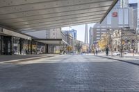 a walkway between the buildings that surround the area on this city street that is full of shops, people and bikes