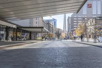 a walkway between the buildings that surround the area on this city street that is full of shops, people and bikes