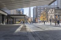 a walkway between the buildings that surround the area on this city street that is full of shops, people and bikes