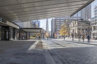 a walkway between the buildings that surround the area on this city street that is full of shops, people and bikes