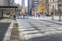 a walkway between the buildings that surround the area on this city street that is full of shops, people and bikes