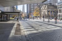 a walkway between the buildings that surround the area on this city street that is full of shops, people and bikes