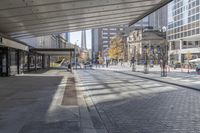 a walkway between the buildings that surround the area on this city street that is full of shops, people and bikes