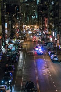 police cars are driving down a street in a city at night in the usa or europe