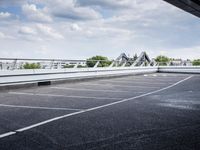 a street view of a bridge with the sky in the background and white lines on the pavement