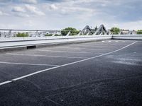 a street view of a bridge with the sky in the background and white lines on the pavement