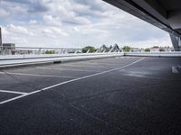 a street view of a bridge with the sky in the background and white lines on the pavement