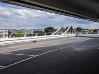 a street view of a bridge with the sky in the background and white lines on the pavement