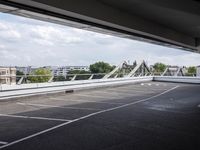 a street view of a bridge with the sky in the background and white lines on the pavement