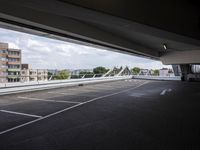 a street view of a bridge with the sky in the background and white lines on the pavement
