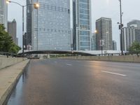 the view down the city street on an overpass near some tall buildings, with a yellow line on the middle of the road