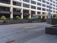 a city street is lined with a yellow line in front of a large building on the sidewalk