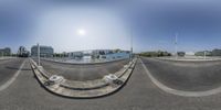 a fisheye lens picture of some white toilets and building's on a street