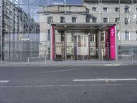 a large building is reflected in the side of the street that goes along this narrow road