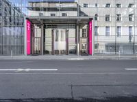 a large building is reflected in the side of the street that goes along this narrow road