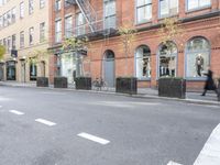 the cars are passing by the buildings on the street of the city streets as people walk near by