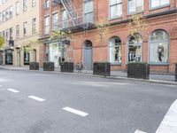 the cars are passing by the buildings on the street of the city streets as people walk near by