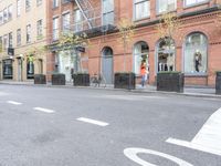 the cars are passing by the buildings on the street of the city streets as people walk near by
