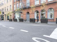 the cars are passing by the buildings on the street of the city streets as people walk near by