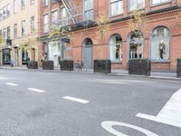 the cars are passing by the buildings on the street of the city streets as people walk near by
