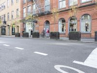 the cars are passing by the buildings on the street of the city streets as people walk near by