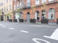the cars are passing by the buildings on the street of the city streets as people walk near by